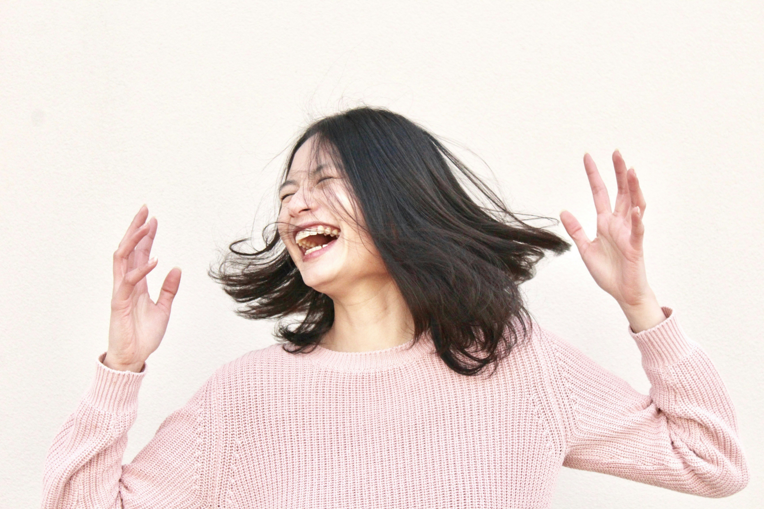 Fun ways to practice gratitude - Joyful Asian woman laughing expressively