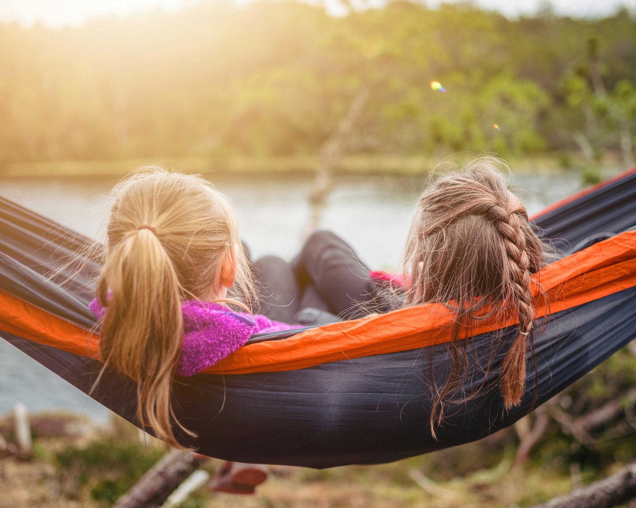 How to raise grateful kids - two girls lying in a hammock enjoying nature