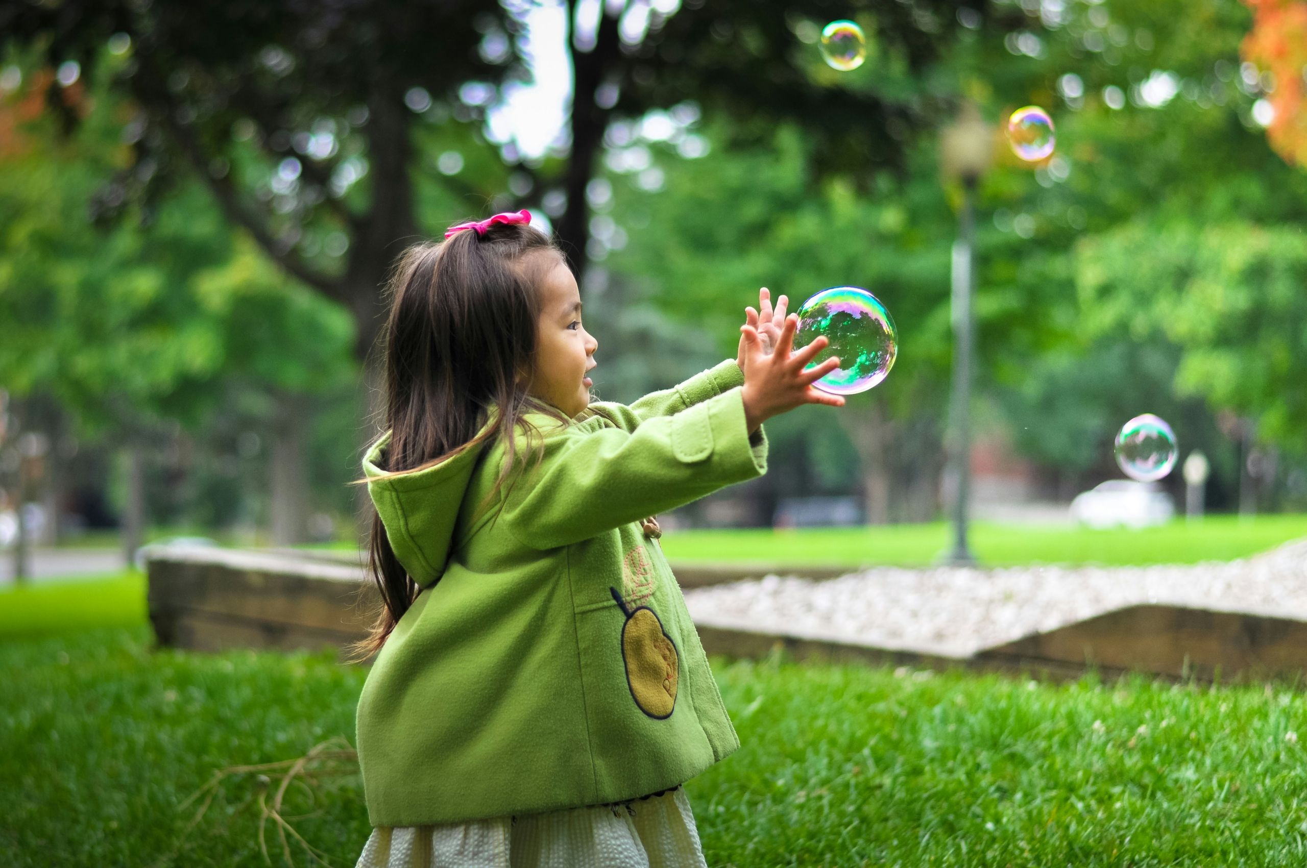 reasons to be grateful - young girl plays with bubbles outside