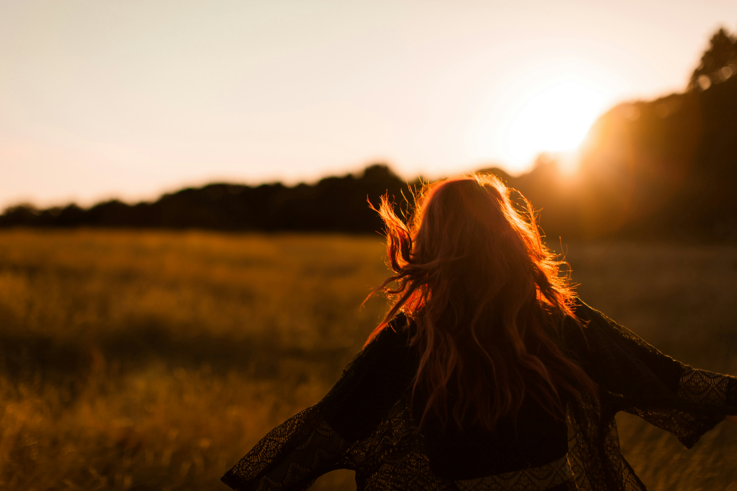gratitude misconceptions - woman in field during sunset silhouette