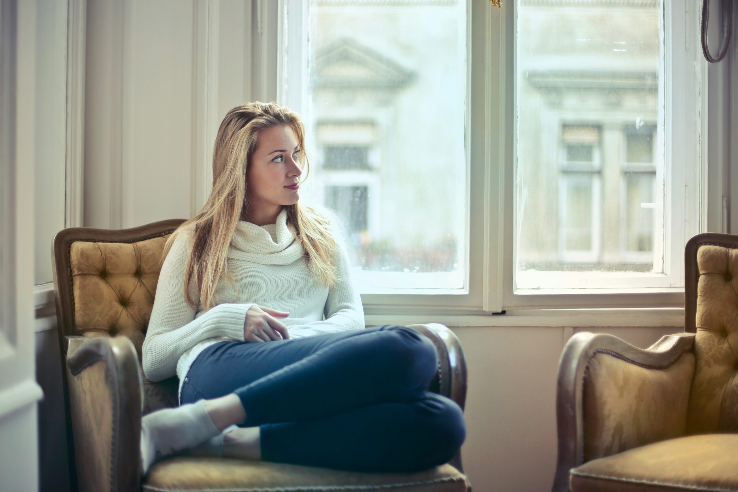 daily gratitude routine for beginners - woman sitting comfortably in a chair next to a bright window